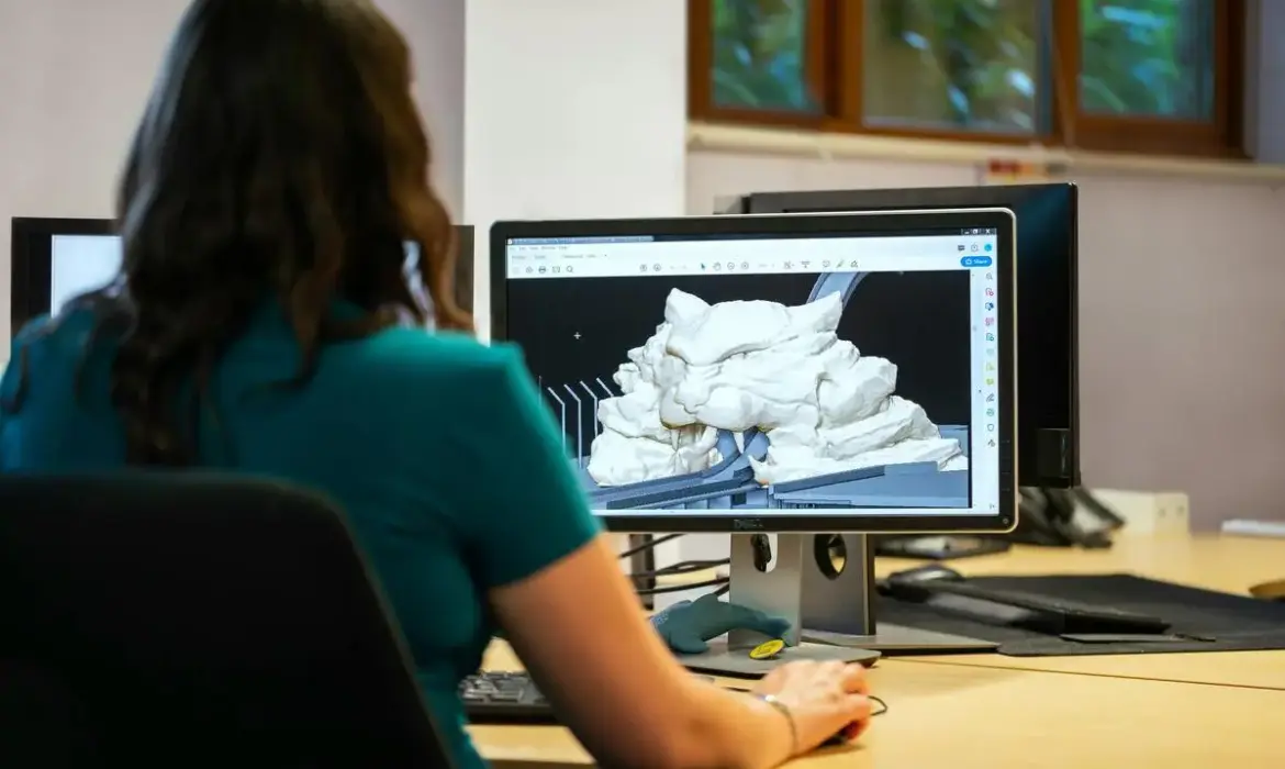 Designer working with 3D modeling software on desktop computer in office