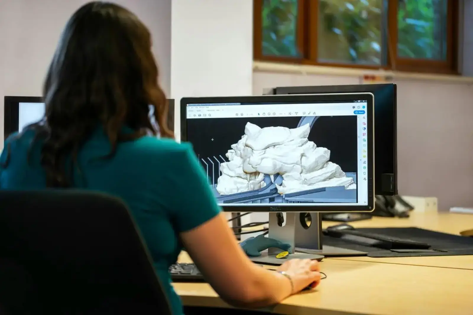 Designer working with 3D modeling software on desktop computer in office